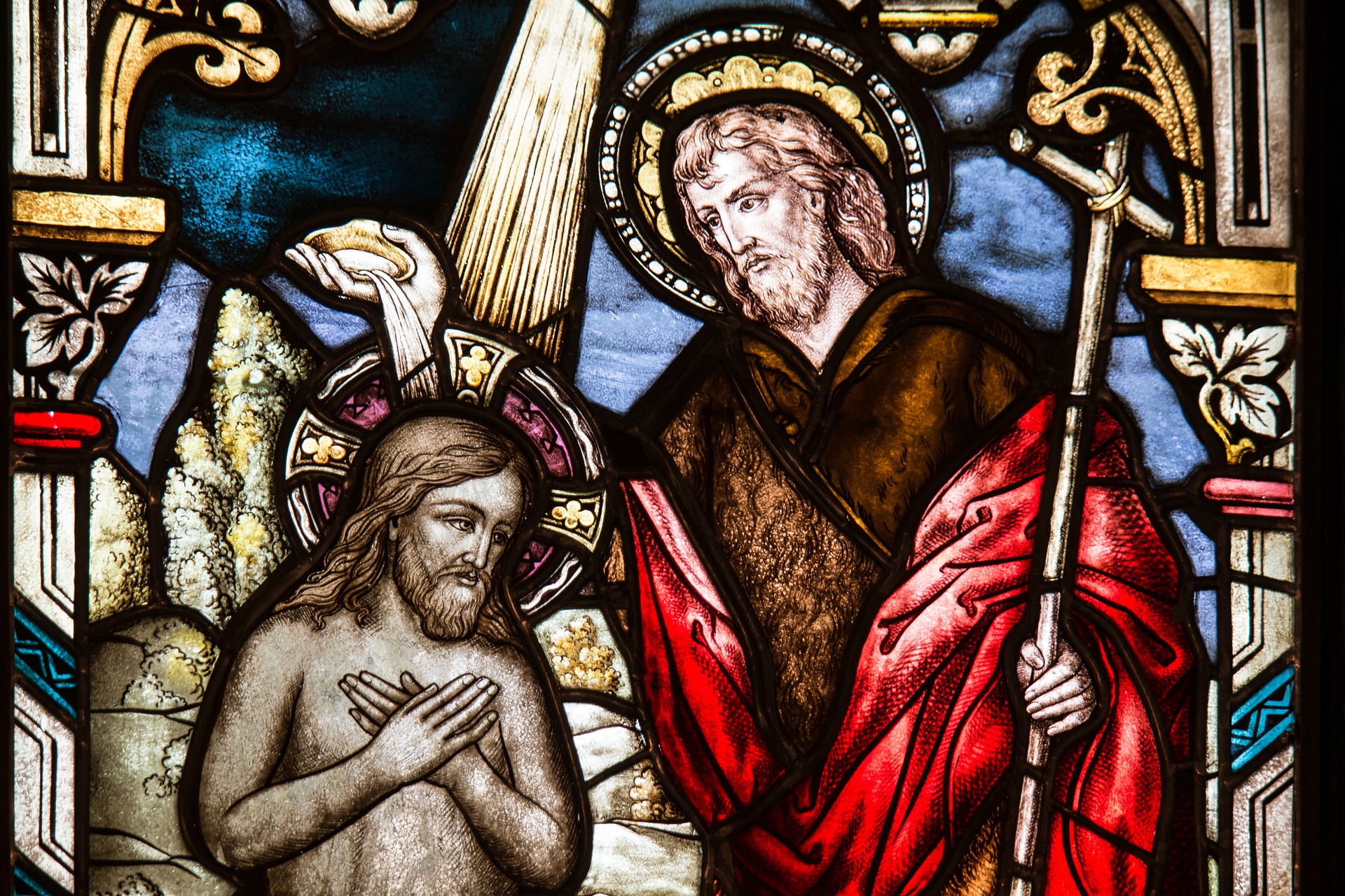 Stained glass depiction of Jesus being baptised.